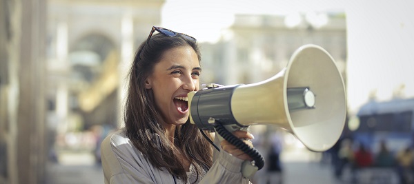 //www.pexels.com/photo/cheerful-young-woman-screaming-into-megaphone-3761509/